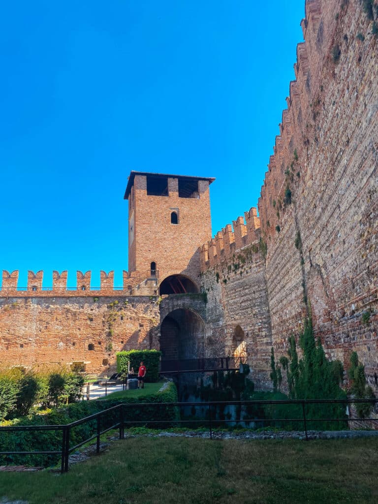 An interior courtyard surrounded by tall brick walls at the Castelvecchio Museum in Verona