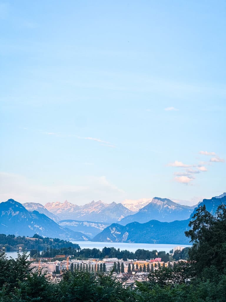 View of Lake Lucerne at sunset with mountains and the city of Lucerne below