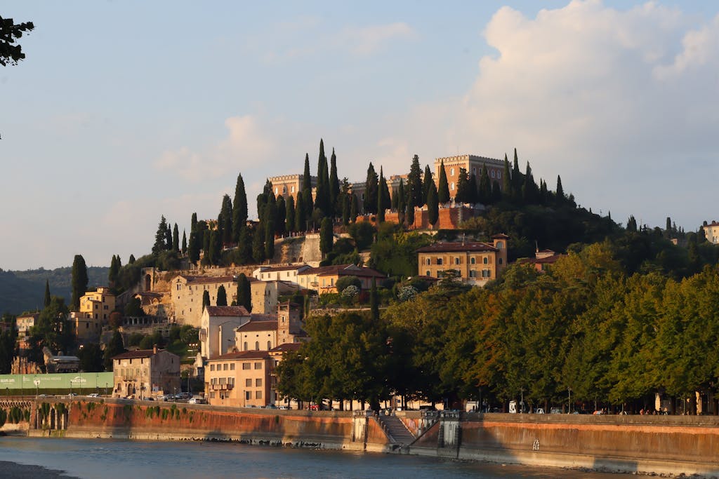 Picturesque landscape of Verona's historic architecture and lush greenery during sunset.