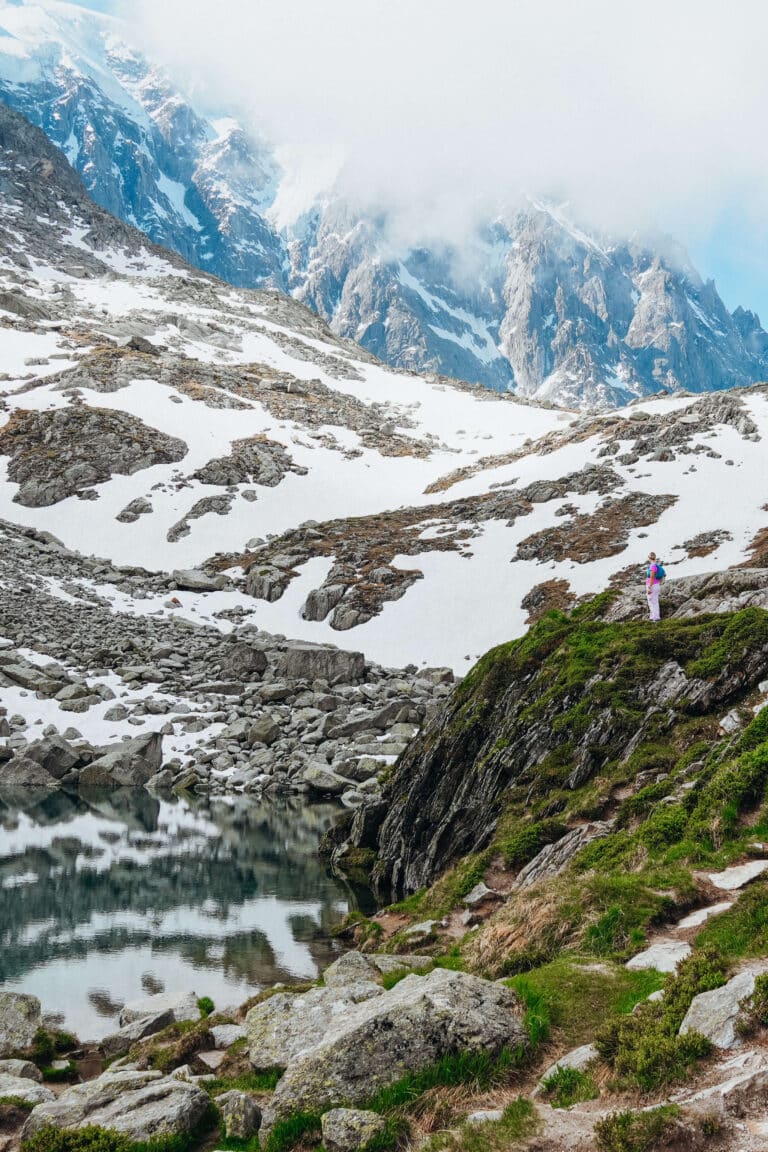 Lac Bleu shrouded in clouds, with a traveler in the foreground