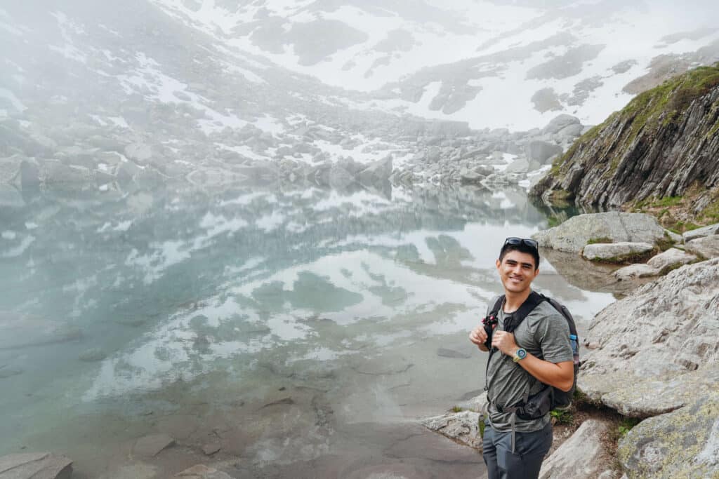 A traveler standing in a misted over lake at Lac Bleu