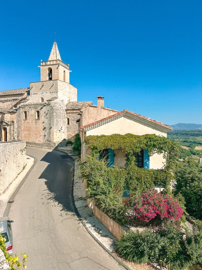 Hilltop view toward Venasque’s church and stone buildings with the countryside stretching beyond.