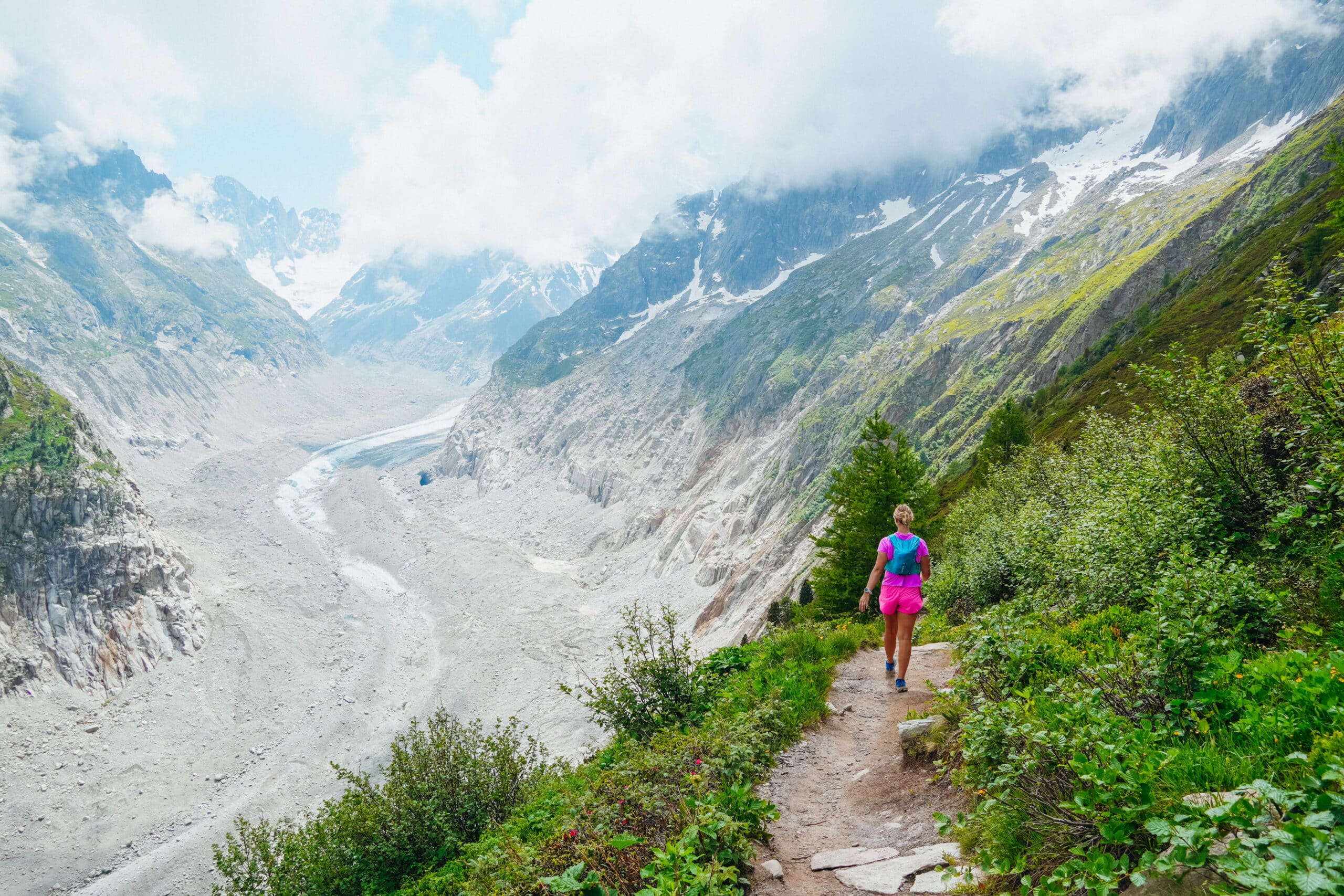 A happy hiker trots along the Signal Forbes trail above the Mer de Glace