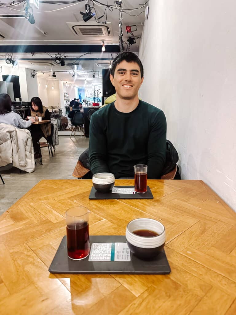 Travel Buddy at a wooden table with a specialty coffee set served on a tray.