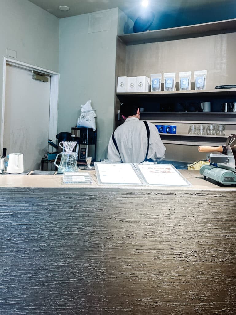 Minimalist specialty coffee bar in Sapporo with a barista working behind the counter.