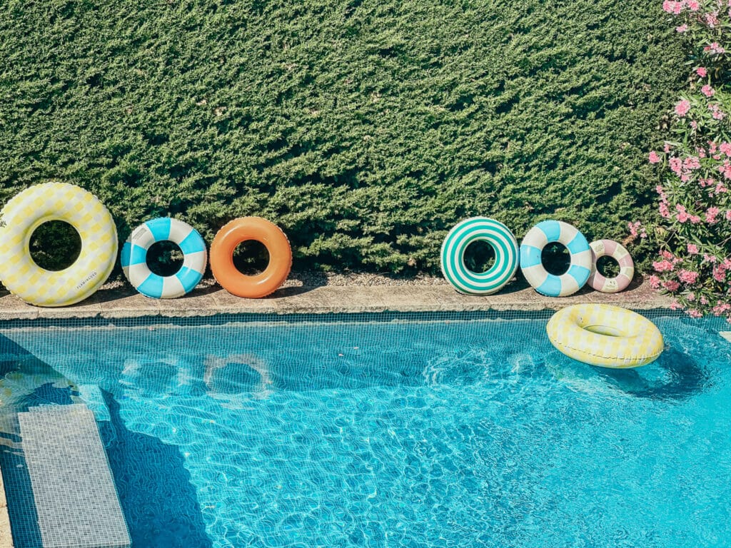 Close-up of the pool edge with colorful float rings at Le Temps Suspendu Provence.