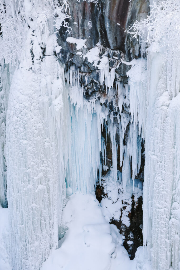 Huge icicles hanging from the rock wall beside Shirahige Waterfall in winter, Shirogane Onsen, Hokkaido.