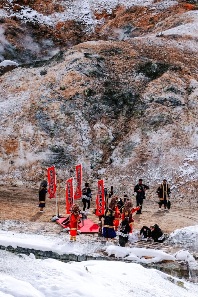 Cultural performance with red oni demon costumes in Noboribetsu Jigokudani Hell Valley.