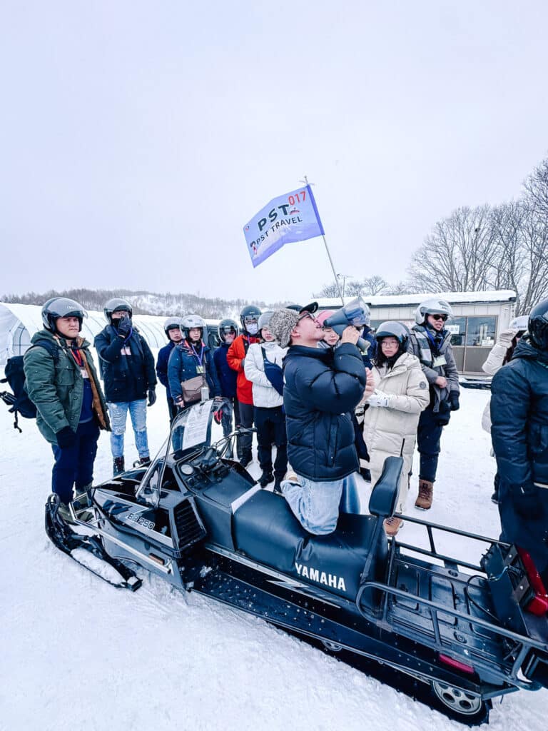 Group of visitors receiving a snowmobile safety demonstration at Snow World Toya in Hokkaido