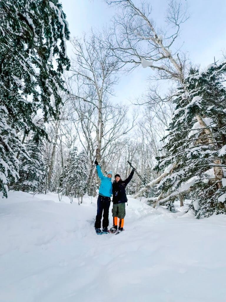 Couple posing together in snowshoes during a guided snowshoe tour in Biei