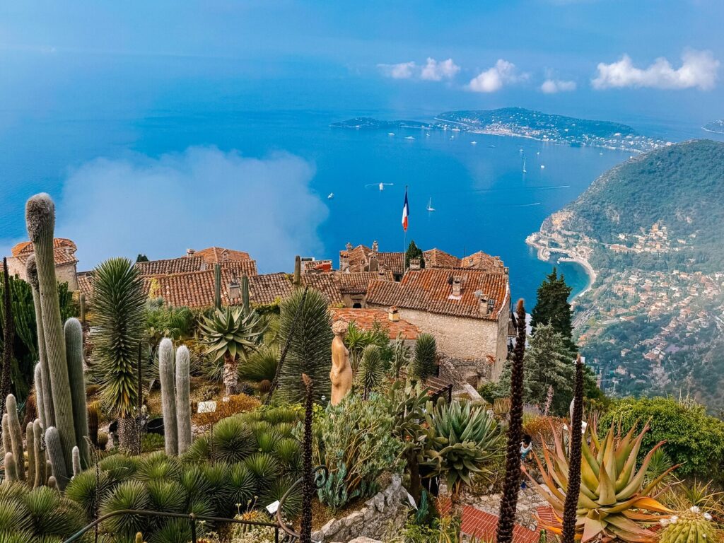 Cacti and succulents in the foreground of a sweeping panoramic view of the Côte d'Azur coastline from Eze village