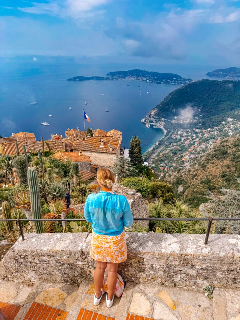 A visitor enjoying the view of the coastline from the Jardin Exotique at the top of Eze