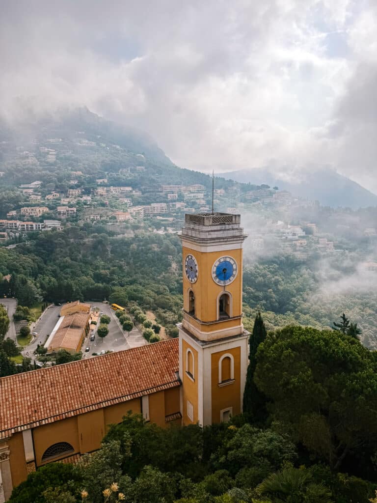 Dramatic view of the Eze village church tower and surrounding mountains from the Jardin Exotique d'Eze on the French Riviera on a cloudy day