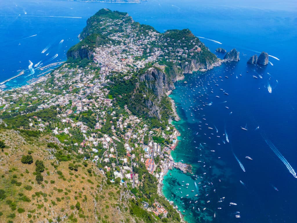 An aerial view of the island of Capri, focused on Capri Town Center, Marina Grande, and Marina Piccola