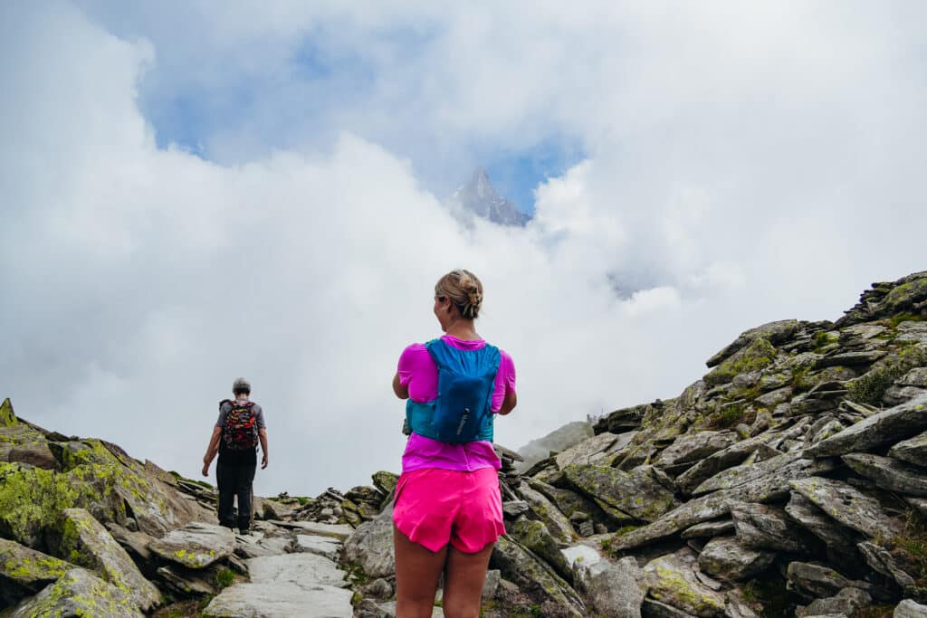Female hiker pausing at a Grand Balcon Nord viewpoint at Signal Forbes overlooking the Mer de Glace glacier in Chamonix