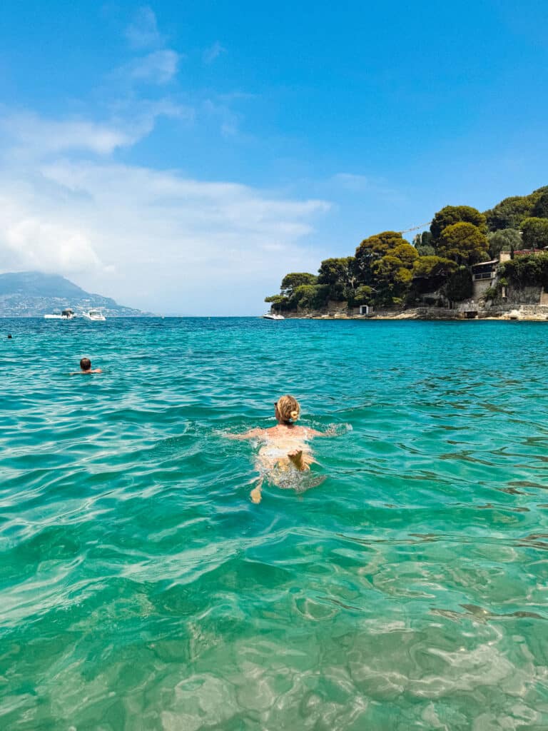 Swimmer floating in clear turquoise water at Paloma Beach in Cap Ferrat