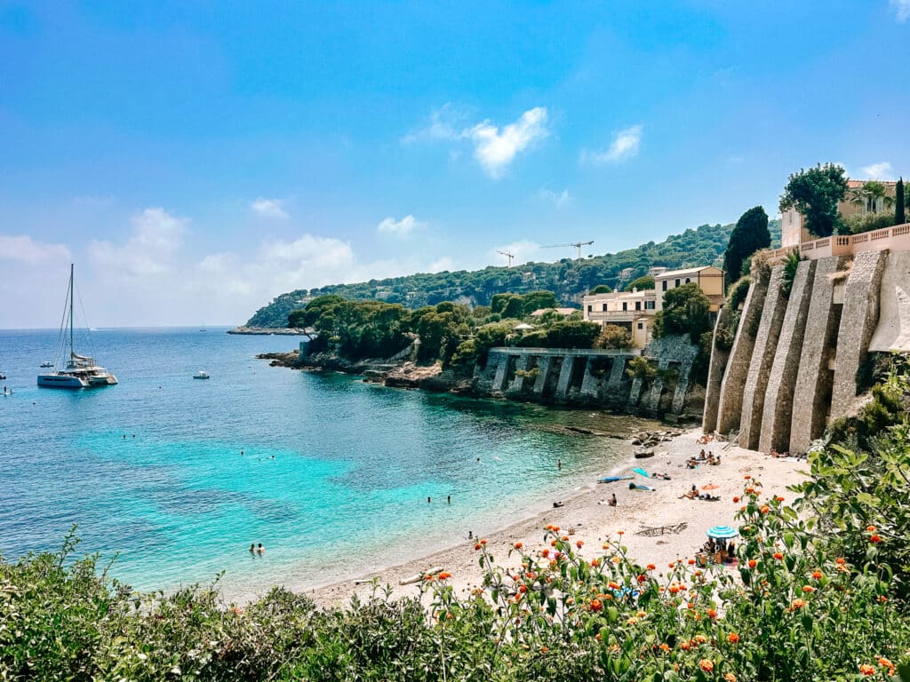 Sparkling sea under a bright blue sky with little yachts floating offshore at Plage des Fossettes on Saint-Jean-Cap-Ferrat