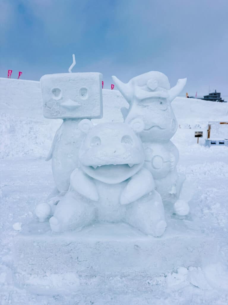 Trio of Pokemon-inspired snow sculptures of Slowpoke and friends under a blue sky at Asahikawa Winter Festival.