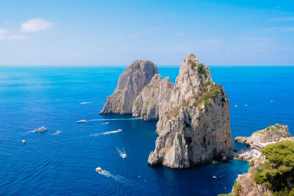 The iconic Faraglioni sea stacks rising from the deep blue Tyrrhenian Sea off the coast of Capri, Italy