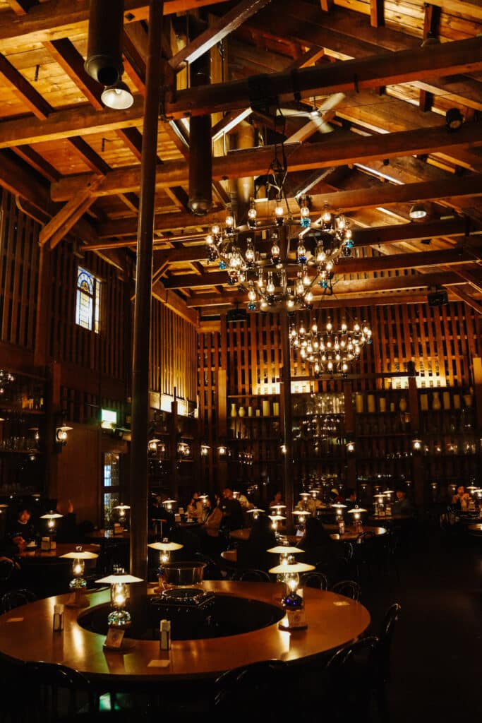 Kitaichi Hall café in Otaru lit by a chandelier of kerosene lamps above wooden tables in a timber warehouse