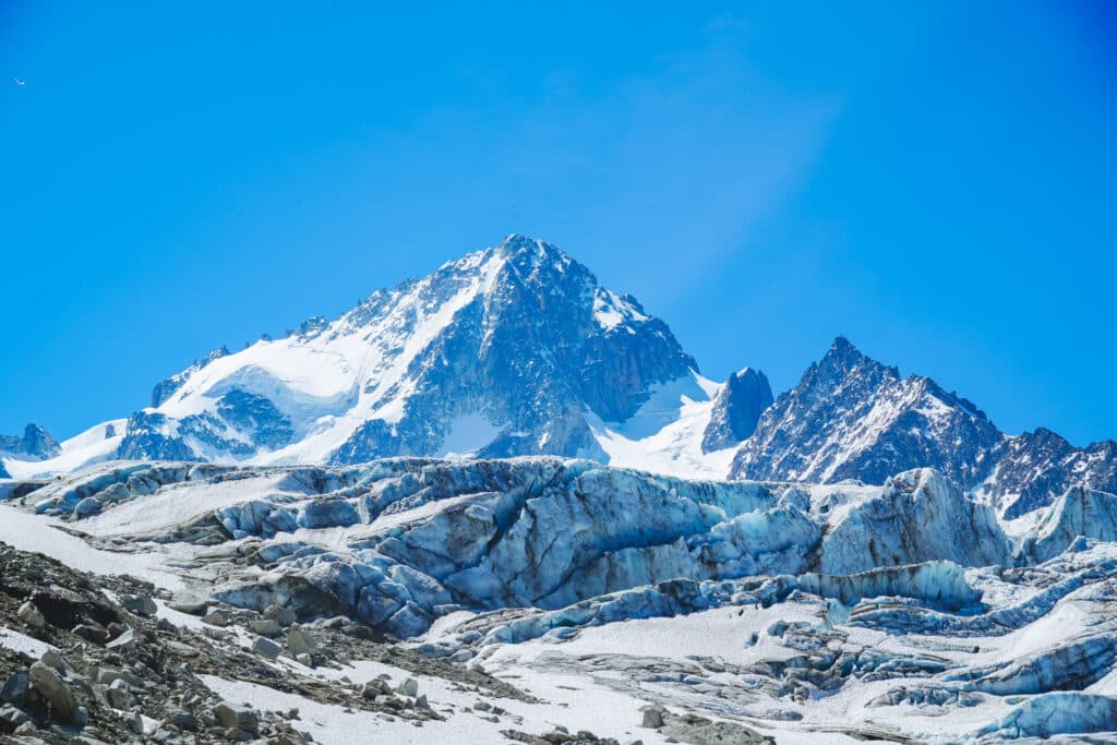 Sharp snowy summit above blue glacial ice on the Albert 1er refuge trail, Chamonix, France