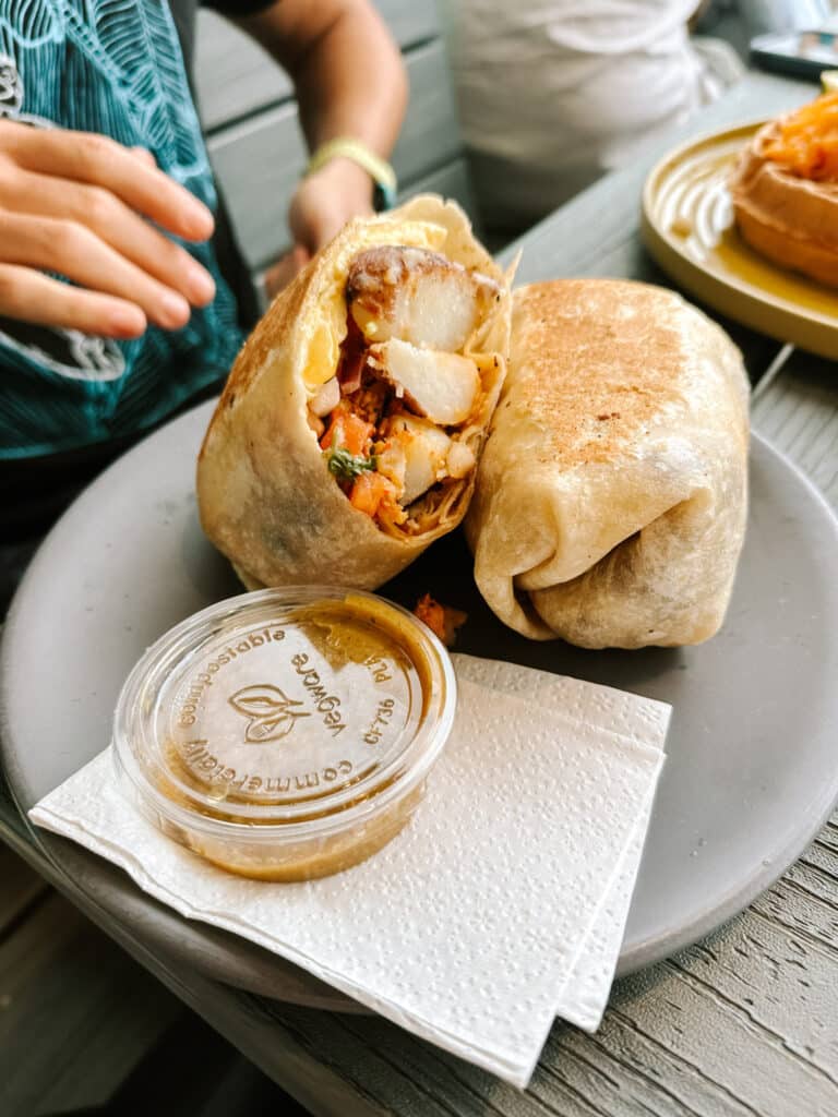Java Kai breakfast burrito with potatoes, eggs and salsa cut in half on a plate in Kapaa, Kauai