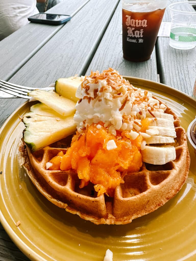Java Kai tropical waffle topped with whipped cream, toasted coconut, mango, banana and pineapple in Kapaa, Kauai