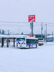 Furano Bus Lavender-liveried local bus and a Hokkaido Chuo Bus coach at the snowy Furano bus terminal, Japan